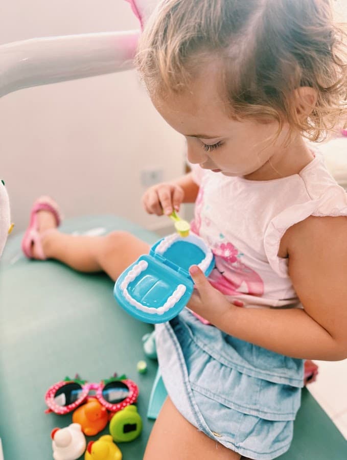 Criança brincando com kit dental lúdico no consultório